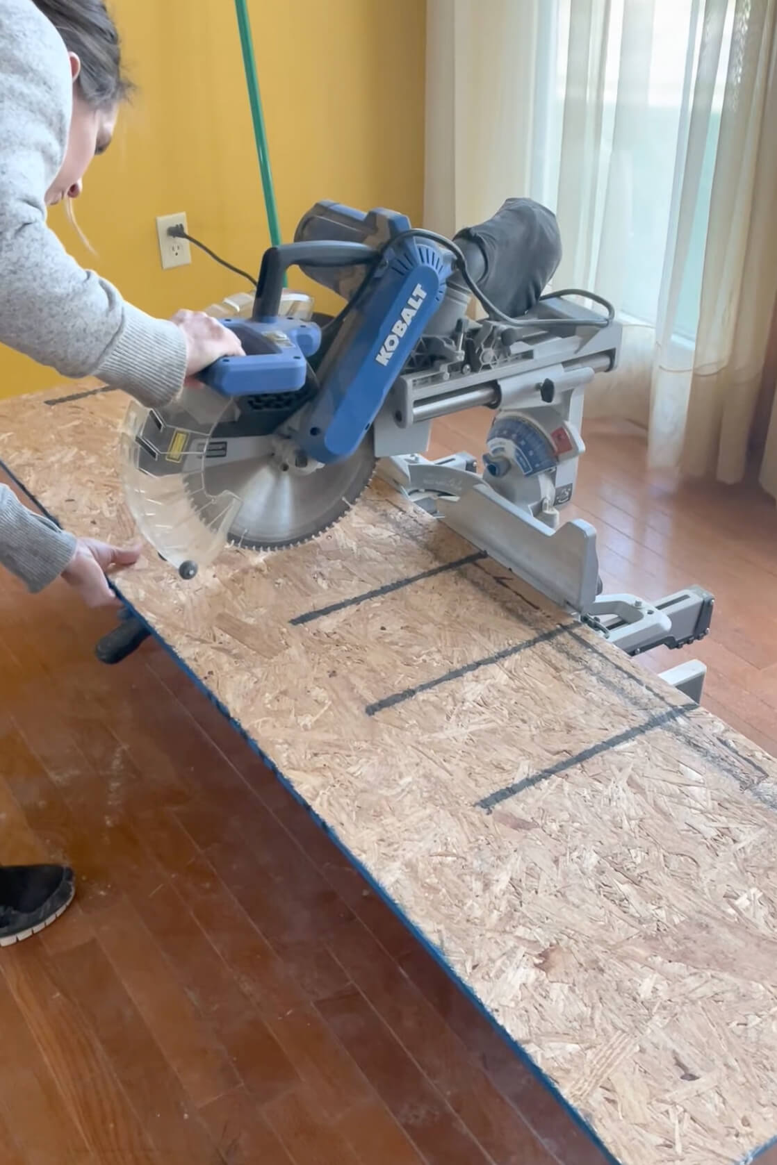 Using a miter saw to cut wood to make an arched doorway.
